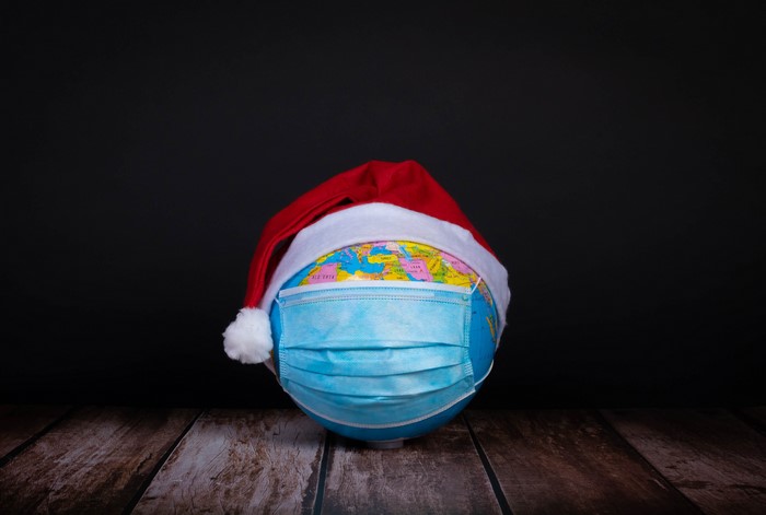 Globe with Santa hat and mask on wood
