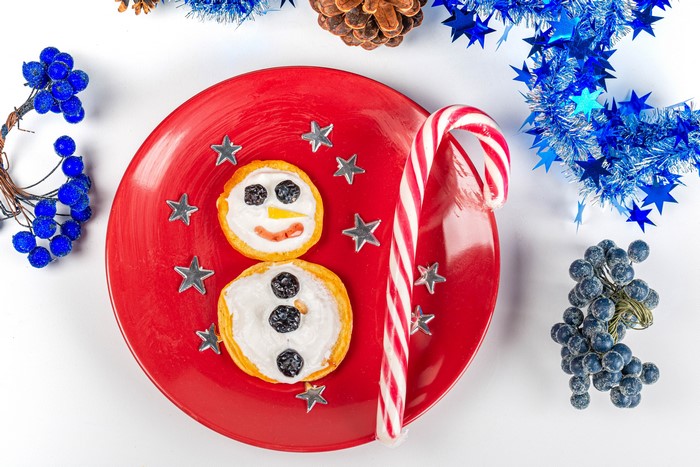 Christmas snowman pancake with candy cane on red plate