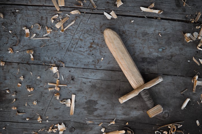 Wooden sword on wood planks with wood shavings