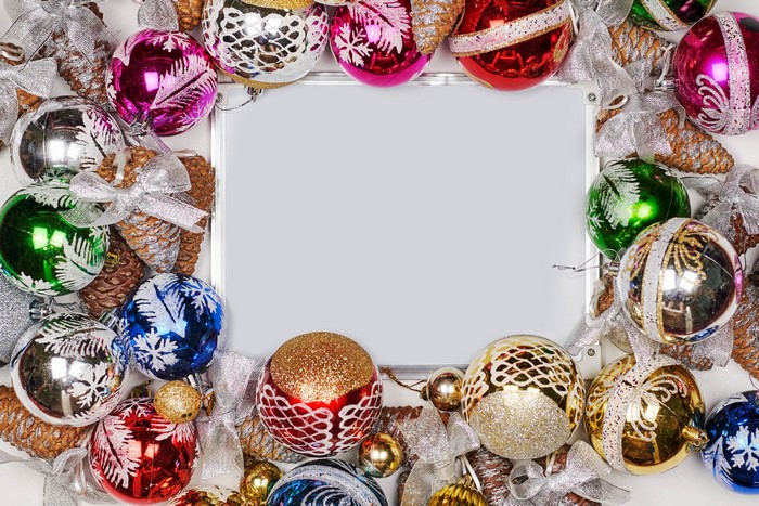 Christmas balls and pine cones frame a blank card