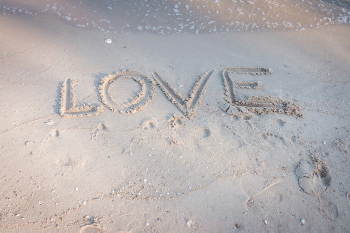 Love written in sand on a beach