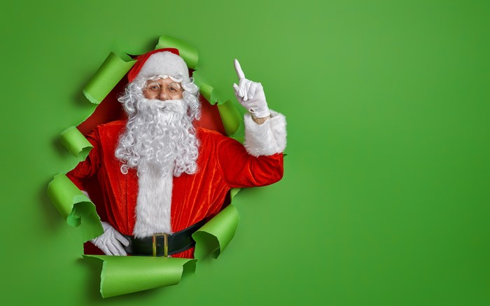 Santa Claus breaking through a green background