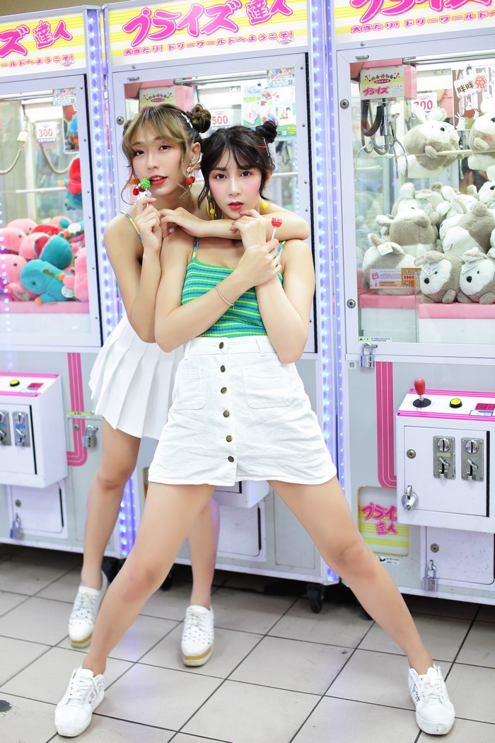 Two Asian girls in front of claw machines