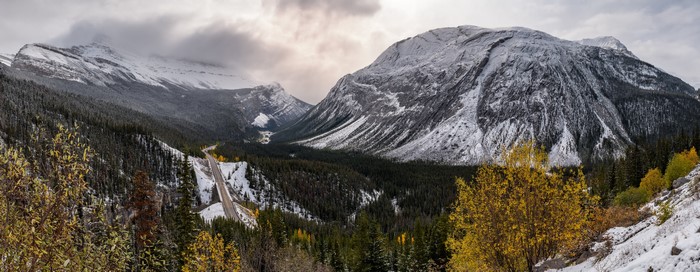 Panorama of snow-capped mountains and a road in Alberta, Canada