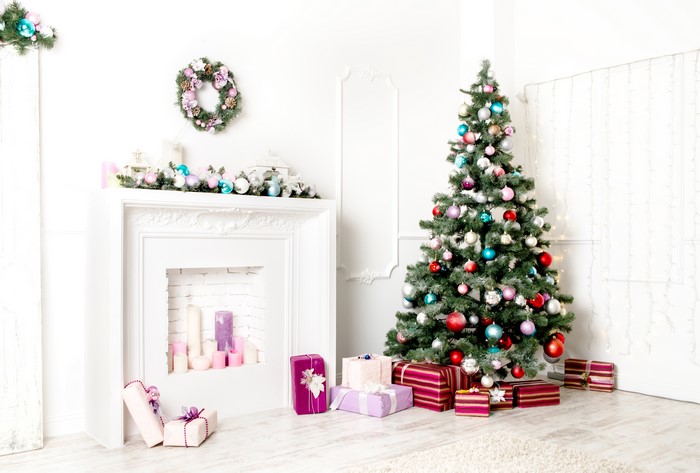 Christmas tree with ornaments and gifts by fireplace