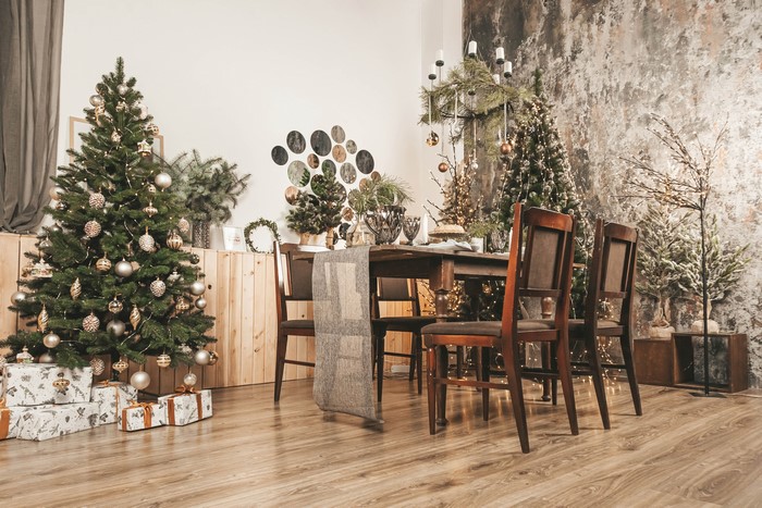 Christmas dining room with decorated trees and gifts