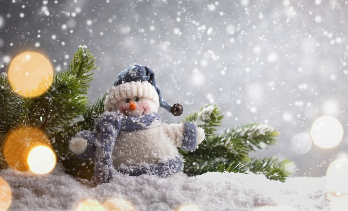 Snowman with Christmas tree branches and bokeh lights