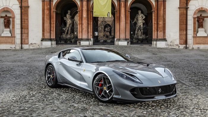 Grey Ferrari 812 Superfast parked in front of a building