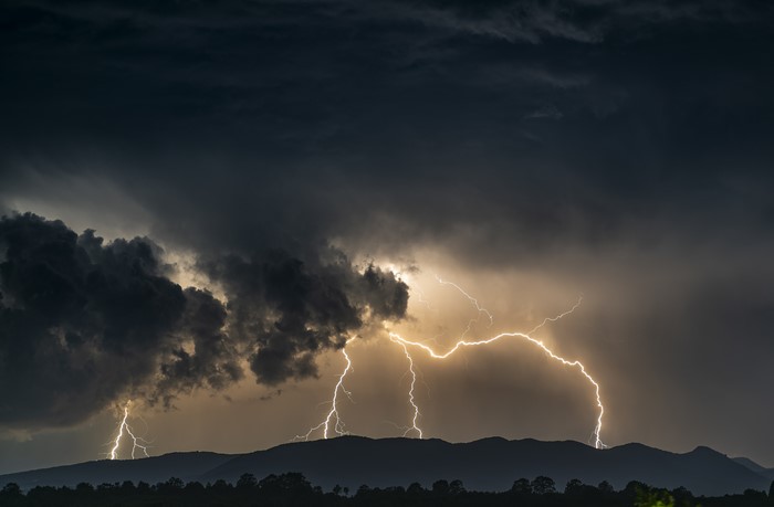 Lightning strikes over mountains during a thunderstorm