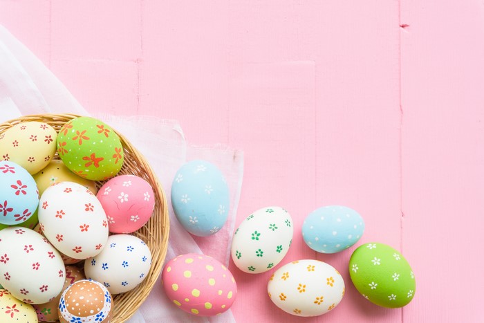 Easter Eggs in a Basket on Pink Background