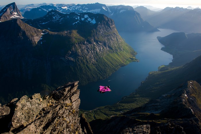 Wingsuit flyer over a Norwegian fjord near Slogen