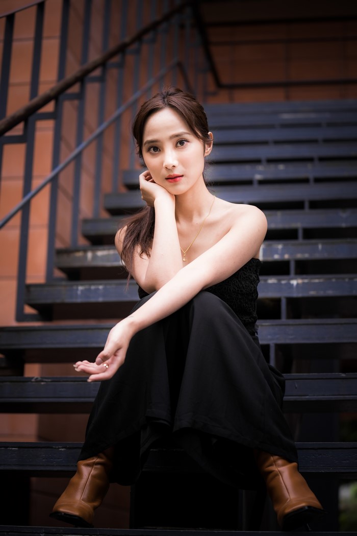 Asian woman sitting on dark stairs