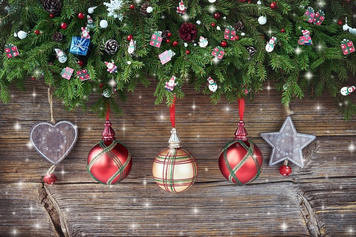 Christmas fir branches with ornaments on wooden background