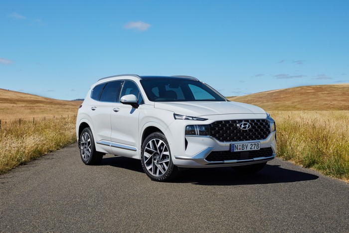 White Hyundai Santa Fe Highlander on a road