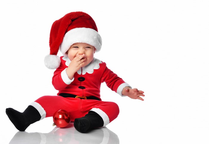 Baby in Santa costume with Christmas ornament