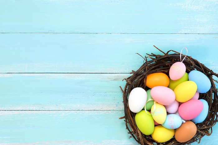 Easter eggs in a nest on blue wooden planks