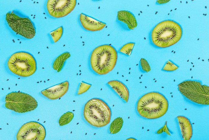 Kiwi slices and mint leaves on a blue background