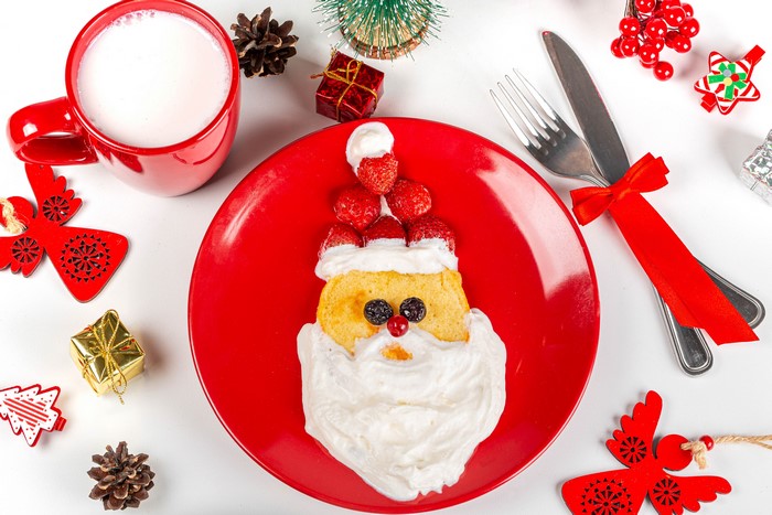Santa Claus pancake with milk and Christmas decorations