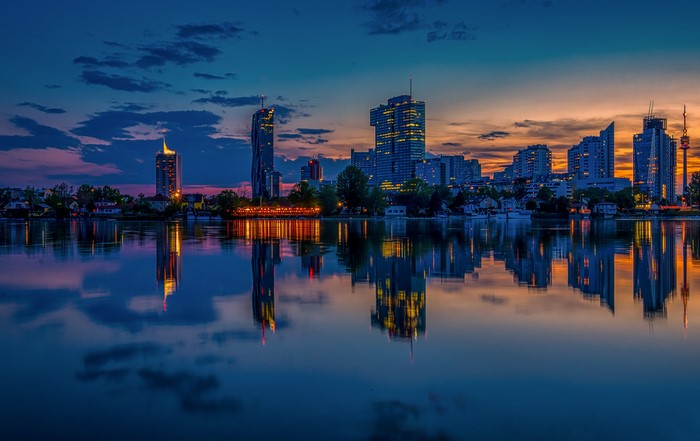 Vienna skyline at dusk with river reflection