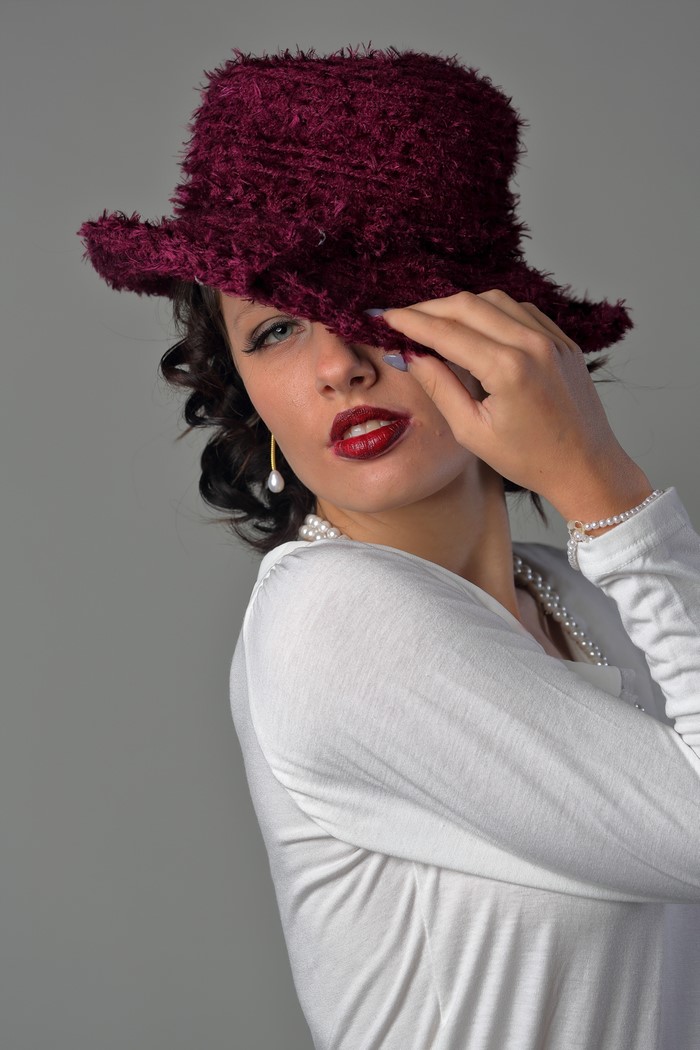 Woman in a burgundy hat and white shirt