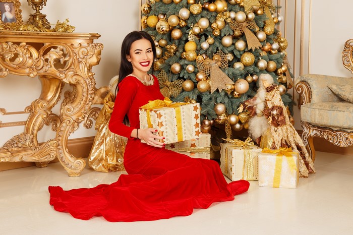 Woman in red dress with Christmas gifts