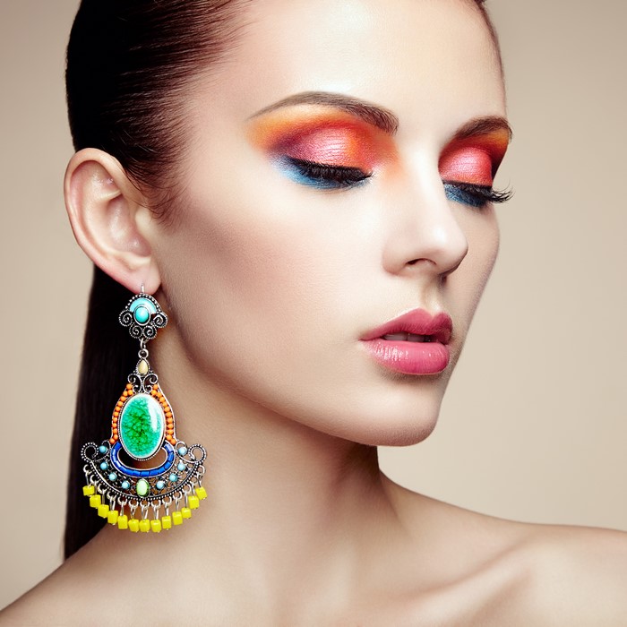 Woman with colorful makeup and large earrings