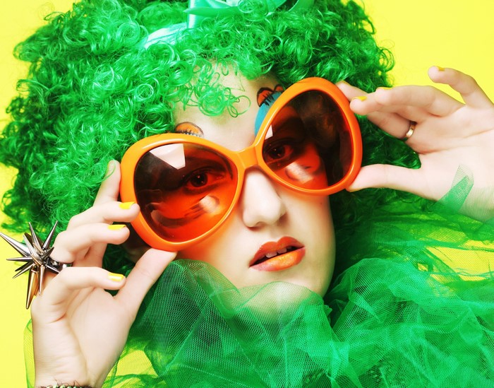 Woman with green wig and orange sunglasses