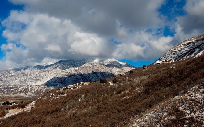 Snow-dusted mountains under a cloudy sky