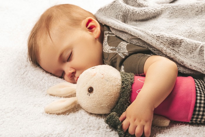 Baby sleeping with a stuffed bunny toy
