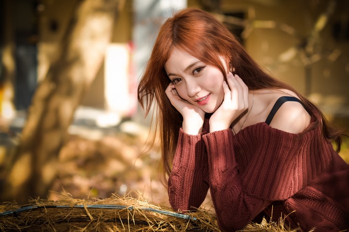 Asian woman with red hair in a sweater
