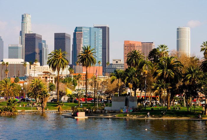 Los Angeles skyline with palm trees and a lake