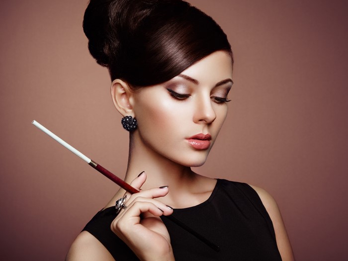Woman with cigarette holder and earrings