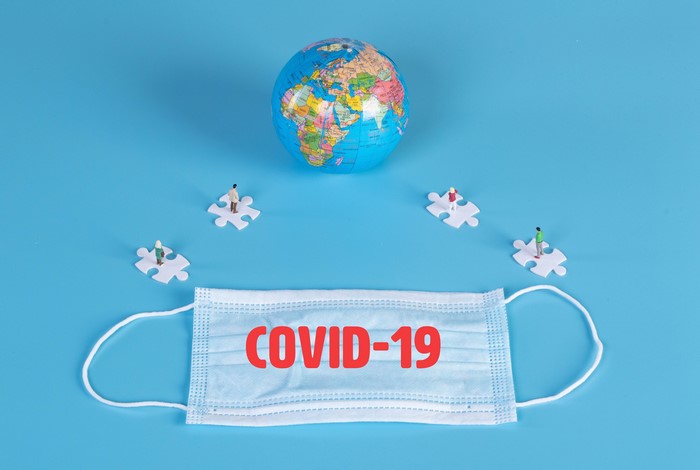 COVID-19 mask and globe with puzzle pieces