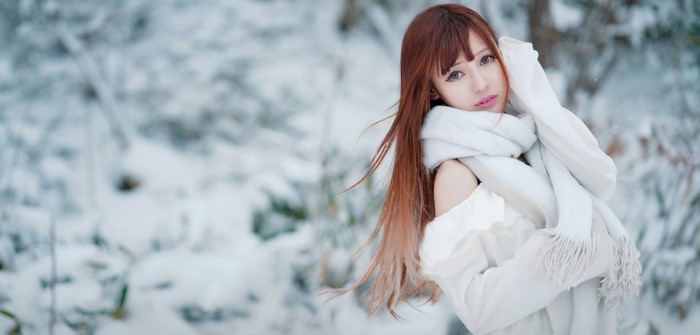 Asian woman with brown hair wearing a scarf in the snow