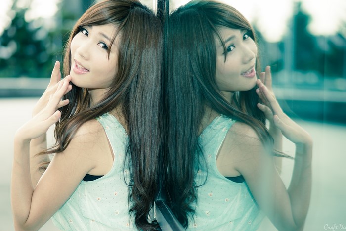 Asian woman with brown hair reflected