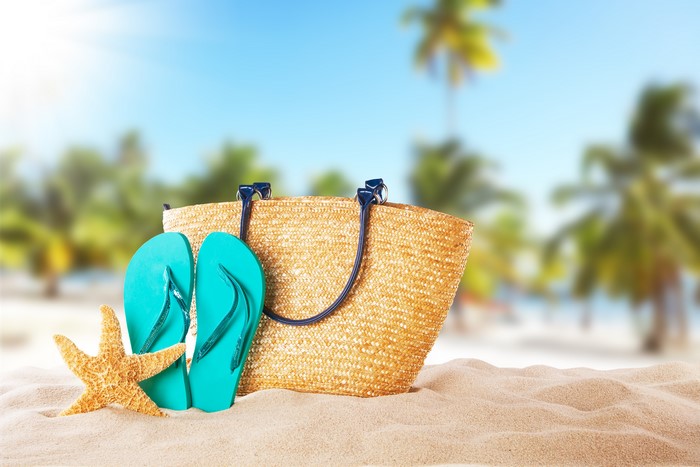 Beach scene with straw bag, flip-flops, and starfish