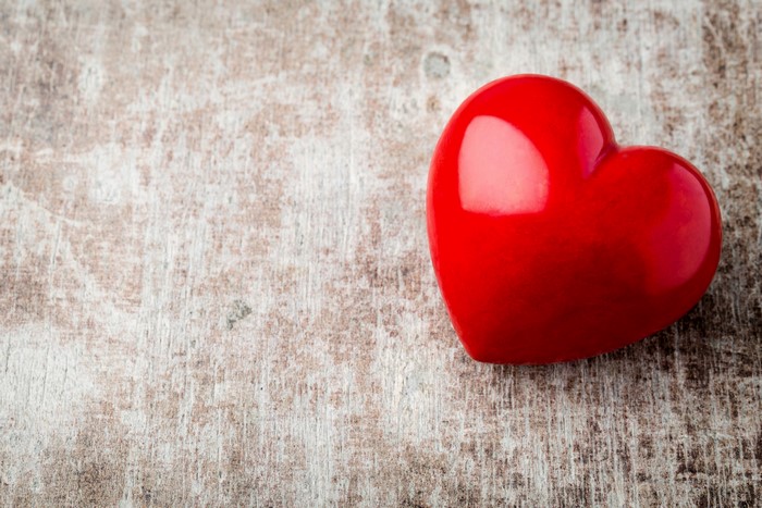 Red Heart on a Textured Wooden Surface