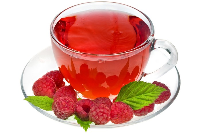 Raspberry tea in a cup with raspberries and leaves