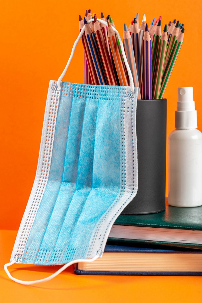 Face mask, colored pencils, spray bottle, and books