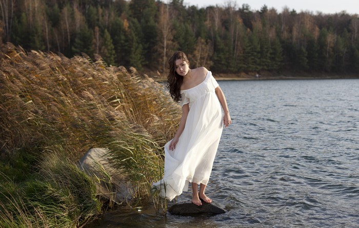 Woman in white dress by a lake