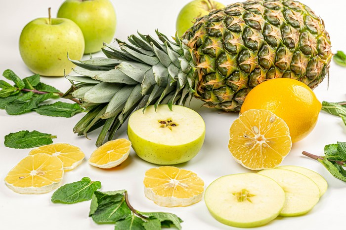 4K Pineapples, Apples, Lemons, and Mint on White Background
