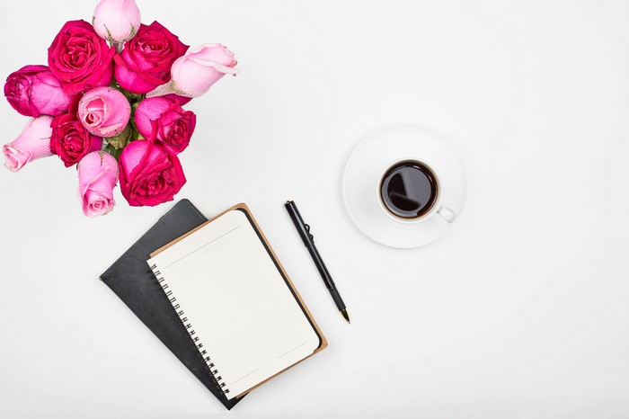 Roses, Coffee, Notepad, and Pen on White Background