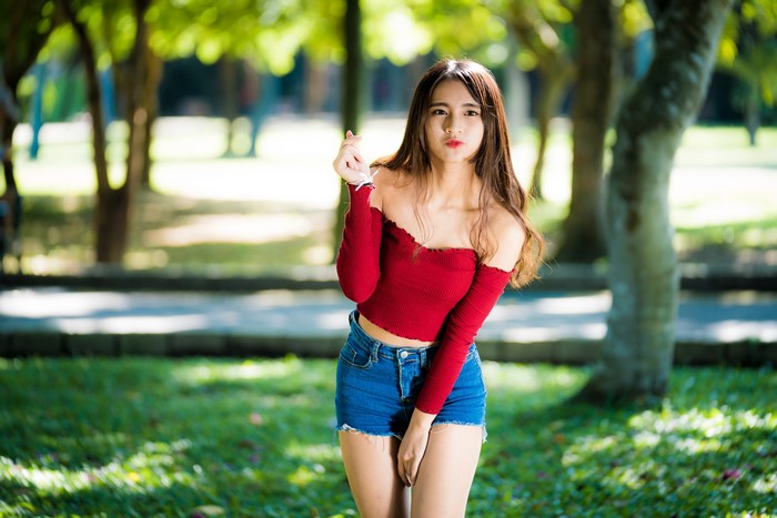 Asian girl in red off-shoulder top and denim shorts
