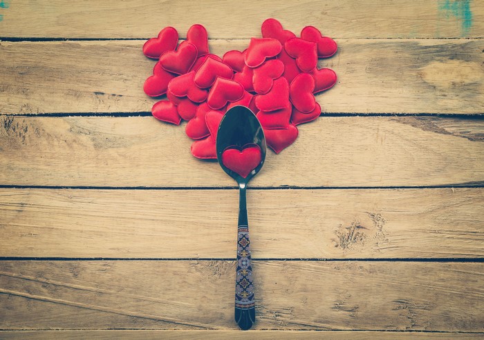 Spoon with hearts on wood planks