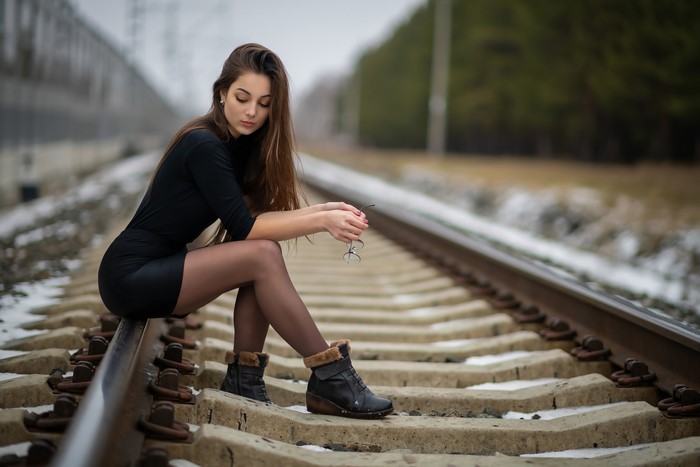 Woman Sitting on Railway Tracks in Bokeh