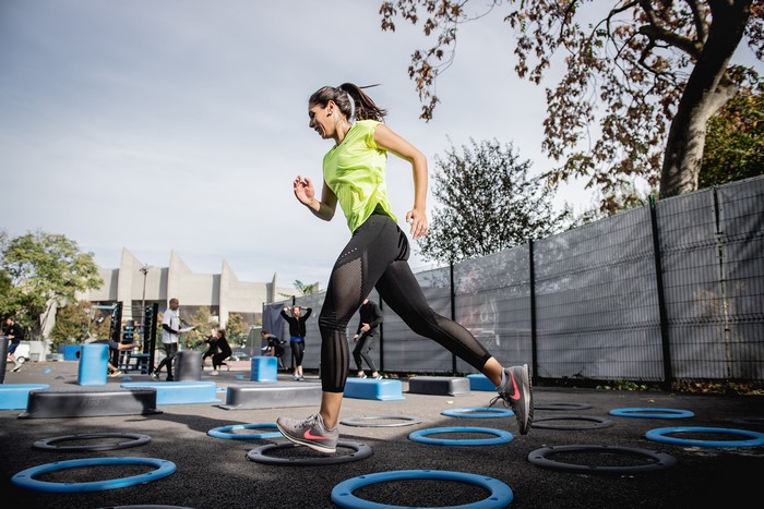 Woman running on agility circles during outdoor fitness workout