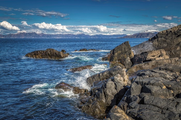 Rocky Coastline in Norway with Snow-Capped Mountains