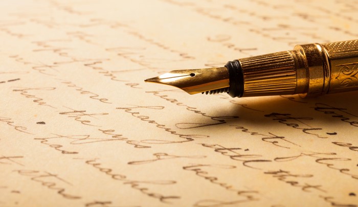 Golden fountain pen on handwritten letter