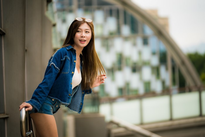 Asian woman with brown hair wearing denim shorts and jacket