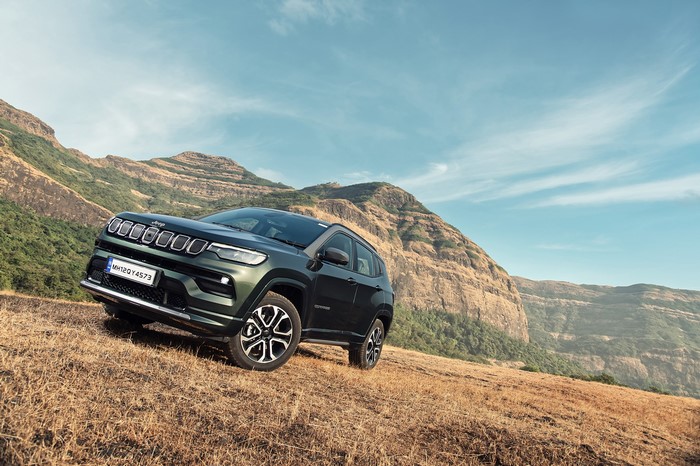 Green Jeep Compass S on a grassy hill
